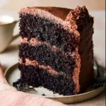 Slice of Ina Garten's famous chocolate cake with rich frosting and chocolate drizzle
