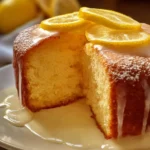 Moist lemon cake topped with creamy lemon frosting on a decorative plate.