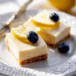 Delicious creamy lemon bars on a platter garnished with lemon slices.