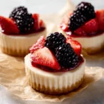 Delicious mini cheesecakes topped with fresh fruit on a white plate