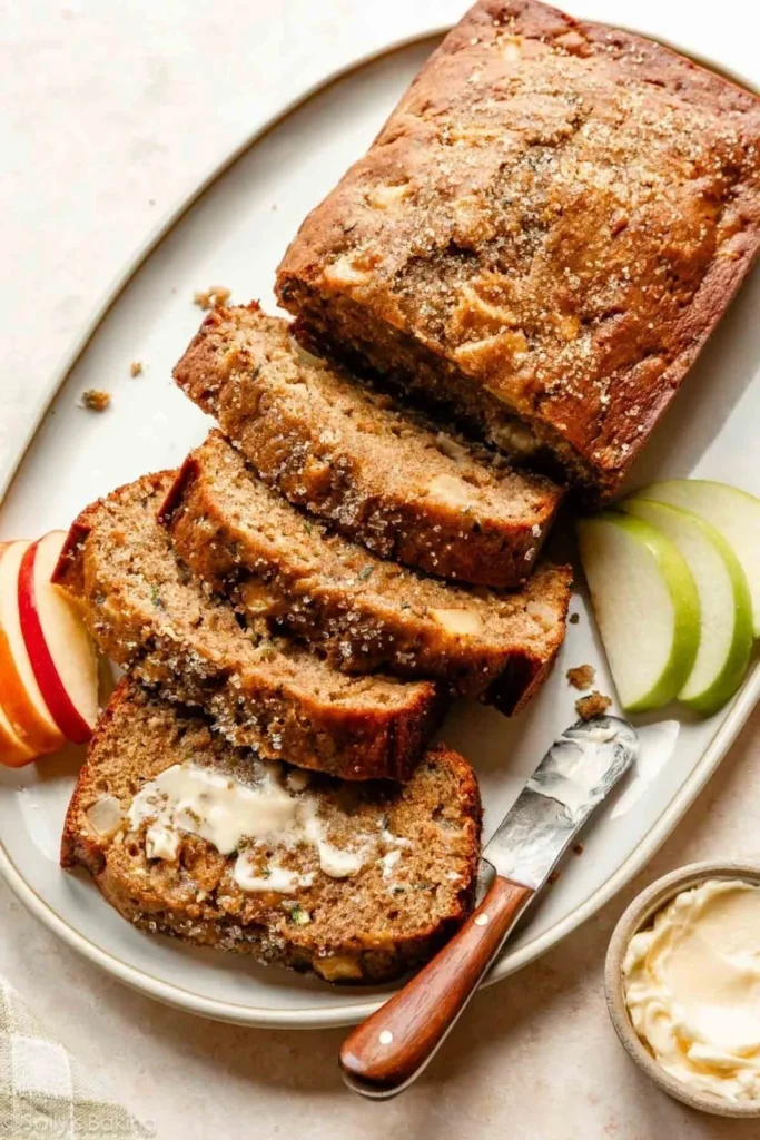 Slice of homemade apple zucchini bread on a wooden table