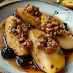 Delicious baked pears topped with honey and walnuts on a serving plate.