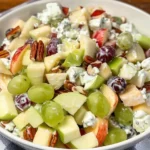 Fruit salad topped with a creamy sour cream dressing and fresh fruit slices.