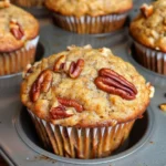 Freshly baked pecan banana muffins with nuts and bananas on a wooden table