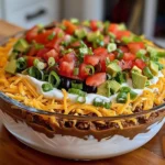 Delicious seven-layer taco dip served in a bowl with fresh toppings
